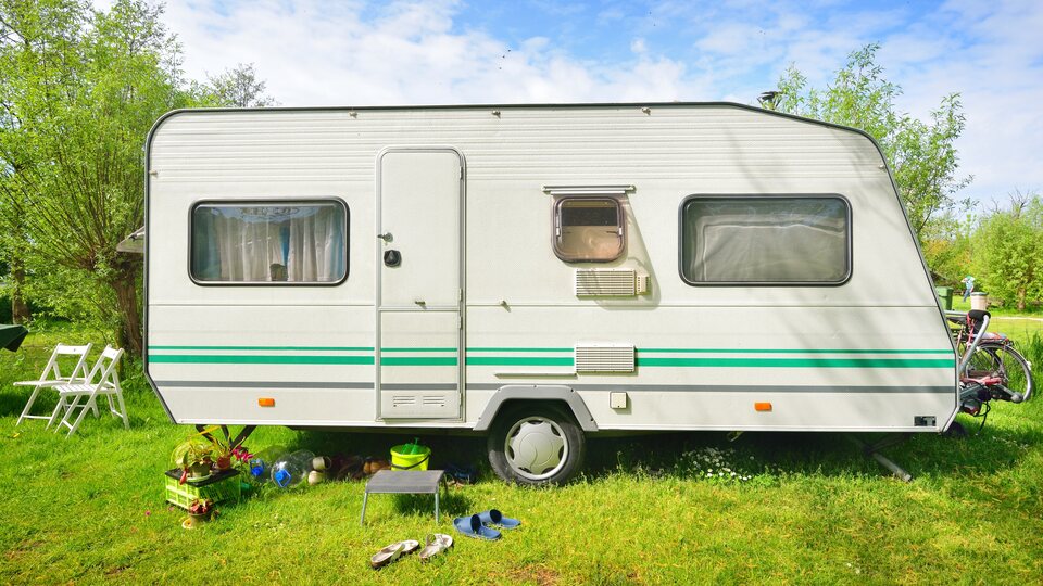 Camper montada con la puerta cerrada en un jardín