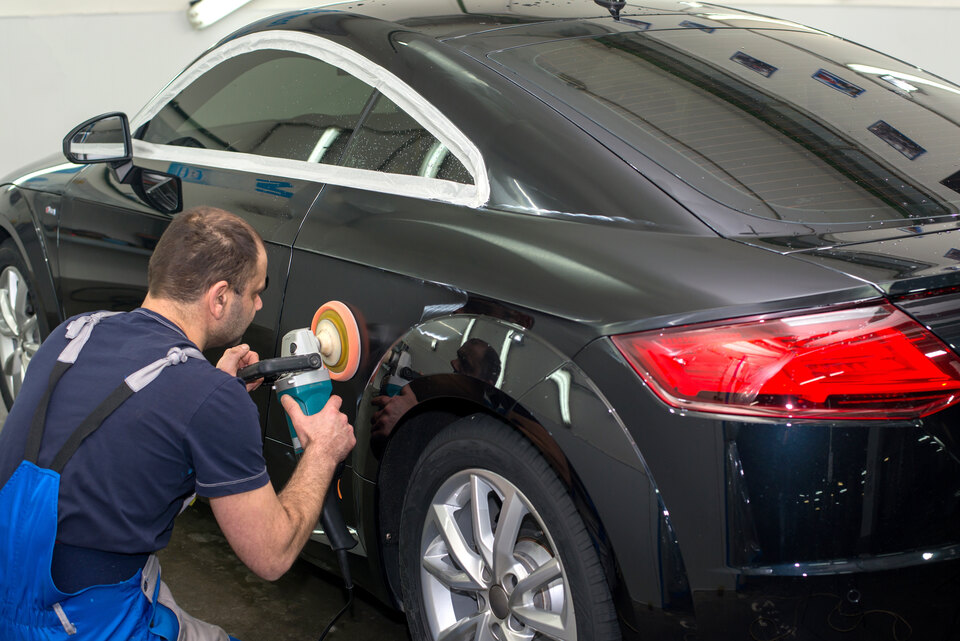 Técnico abrillantando la carrocería de un coche